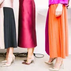 Des robes fluides et plissées, aux couleurs vives et pastel, sont associées à des escarpins élégants. Quelle chaussure avec une robe ? Les talons aiguilles dorés et argentés complètent ces tenues.