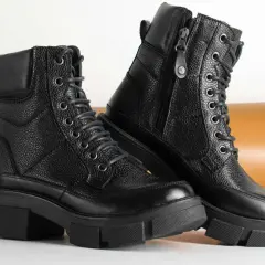 Paire de bottes noires en cuir texturé, parfaites pour un entretien facile. Ces bottes à lacets et fermeture éclair sont prêtes pour toutes vos aventures.