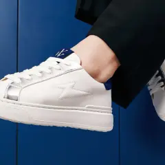 Baskets blanches homme avec détails argentés et logo bleu. Parfaites avec un pantalon noir, elles répondent à la question : quelles chaussettes avec baskets blanches homme ?