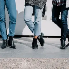 Trois paires de jambes portant des jeans et des bottes, un look décontracté et stylé.