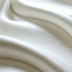 Plis doux de cuir blanc légèrement jauni, évoquant la douceur et la texture d'un tissu. Idéal pour nettoyer cuir blanc jauni.