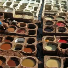 Des cuves remplies de pigments naturels montrent comment est fait le cuir. Des artisans travaillent dans ces bassins de teinture traditionnels.