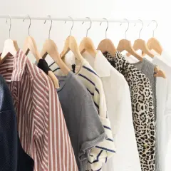Vêtements sur un portant : une garde-robe minimaliste pour comment éviter la surconsommation. Bleu, rayé, léopard, blanc... des pièces intemporelles.