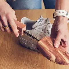 Utilisez un embauchoir en bois pour comment enlever les plis des chaussures. Il maintient la forme et absorbe l'humidité.