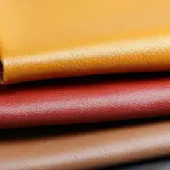 Pile de cuirs synthétiques aux couleurs vives : jaune, rouge, marron et noir. Une belle illustration pour se demander que vaut le cuir PU.
