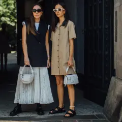 Deux femmes stylées montrent comment porter blazer sans manche femme. L'une porte un blazer noir sur une jupe plissée, l'autre une robe chemise beige.