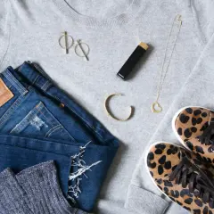 Un pull gris, un jean Levi's, des chaussettes scintillantes, des baskets léopard, un collier cœur, des boucles d'oreilles et un rouge à lèvres Chanel pour s' habiller simplement.