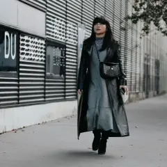 Une femme porte une robe grise et un long manteau noir verni, avec des bottines noires. Elle arbore un sac à main croco. Quelle chaussure mettre avec une robe noire et blanche ?