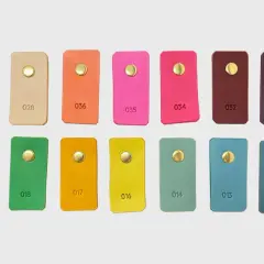 Échantillons de cuir aux teintes variées, du beige au prune, en passant par des couleurs vives comme le rose et l'orange. Chaque pièce présente une couleur de cuir distincte.