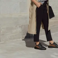 Quelles chaussures avec une combinaison noire ? Des baskets noires avec des détails léopard, parfaites pour un look chic et audacieux.