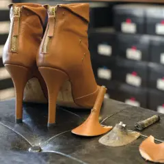 Paired brown leather ankle boots with zippers. One heel shows usure anormale talon chaussure, with the heel tip detached.