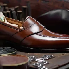 Un élégant mocassin en cuir marron, prêt à être lustré. Ce type de mocassin est un classique intemporel.