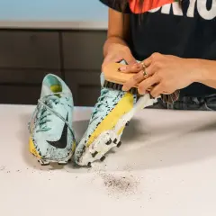 Nettoyage d'une chaussure de football sale, révélant une trace de frottement chaussure sur la semelle.