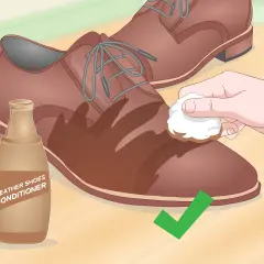Application d'un conditionneur sur une chaussure en cuir pour éviter le cuir qui s'effrite.