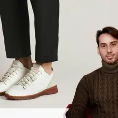 Un homme porte un pull à col roulé et un pantalon cigarette avec une chaussure blanche.