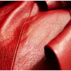 Gros plan sur du skaï rouge plissé, avec des échantillons de textures de skaï rouge et marron. Apprenez comment nettoyer du skaï.