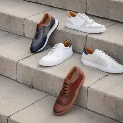 Cinq paires de chaussures élégantes, dont une tenue classe avec basket femme, sont disposées sur des marches en béton.