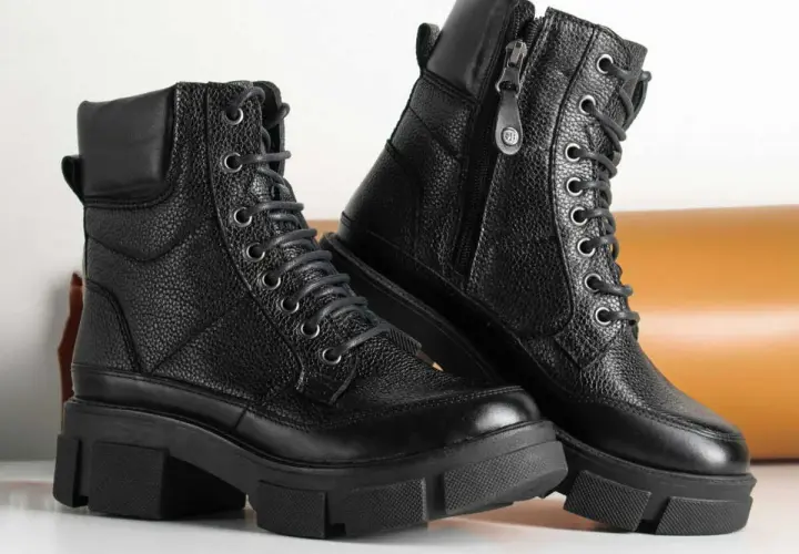 Paire de bottes noires en cuir texturé, parfaites pour un entretien facile. Ces bottes à lacets et fermeture éclair sont prêtes pour toutes vos aventures.