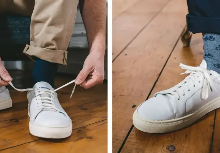 Un homme ajuste sa tenue avec une chaussure blanche homme, des chaussettes à vélos et un pantalon beige retroussé.
