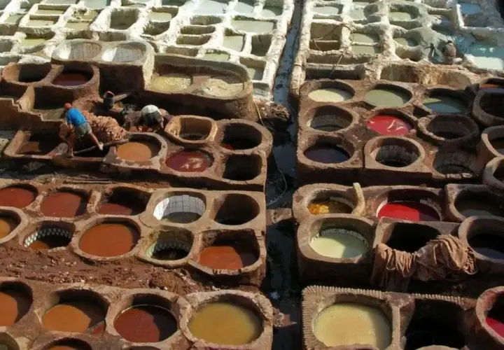 Des cuves remplies de pigments naturels montrent comment est fait le cuir. Des artisans travaillent dans ces bassins de teinture traditionnels.