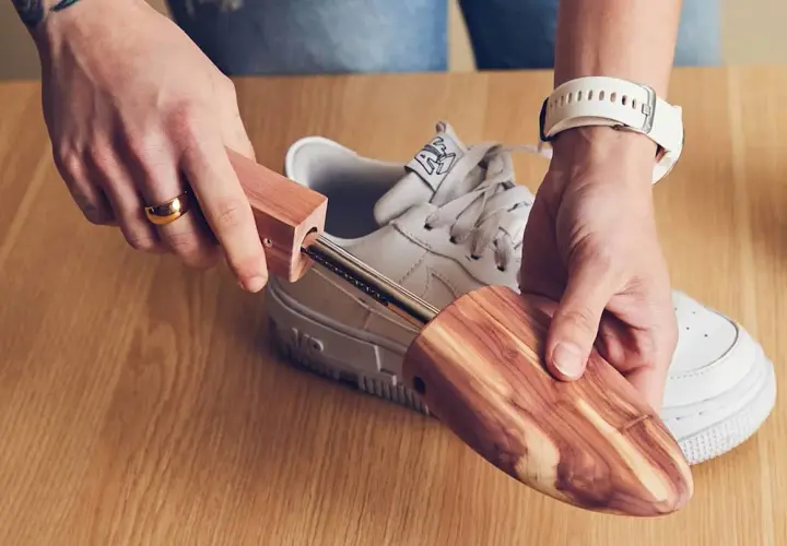 Utilisez un embauchoir en bois pour comment enlever les plis des chaussures. Il maintient la forme et absorbe l'humidité.