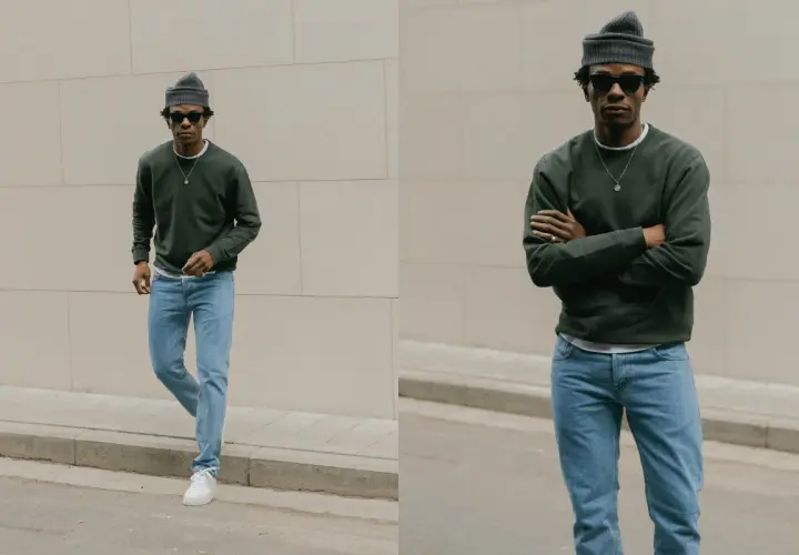 Un homme porte une tenue jean bleu décontractée, un pull vert foncé et un bonnet gris.