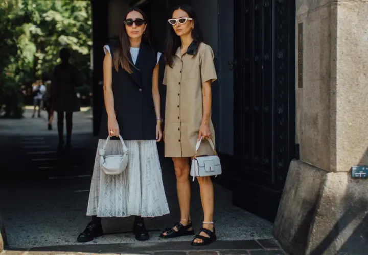 Deux femmes stylées montrent comment porter blazer sans manche femme. L'une porte un blazer noir sur une jupe plissée, l'autre une robe chemise beige.
