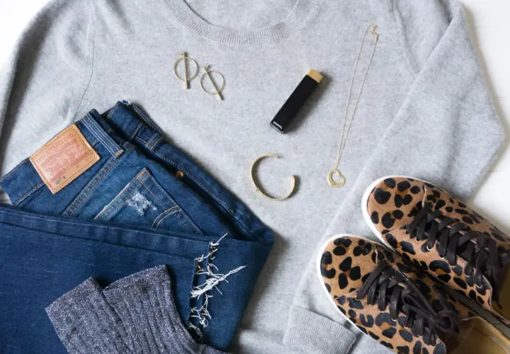 Un pull gris, un jean Levi's, des chaussettes scintillantes, des baskets léopard, un collier cœur, des boucles d'oreilles et un rouge à lèvres Chanel pour s' habiller simplement.