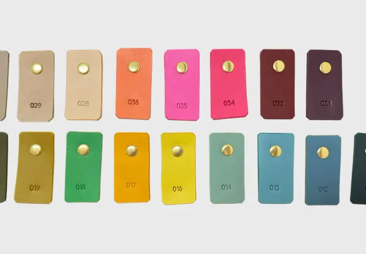 Échantillons de cuir aux teintes variées, du beige au prune, en passant par des couleurs vives comme le rose et l'orange. Chaque pièce présente une couleur de cuir distincte.