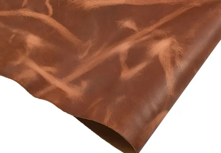 Un morceau de cuir pull up brun, avec des reflets et des marques naturelles, prêt à être transformé.