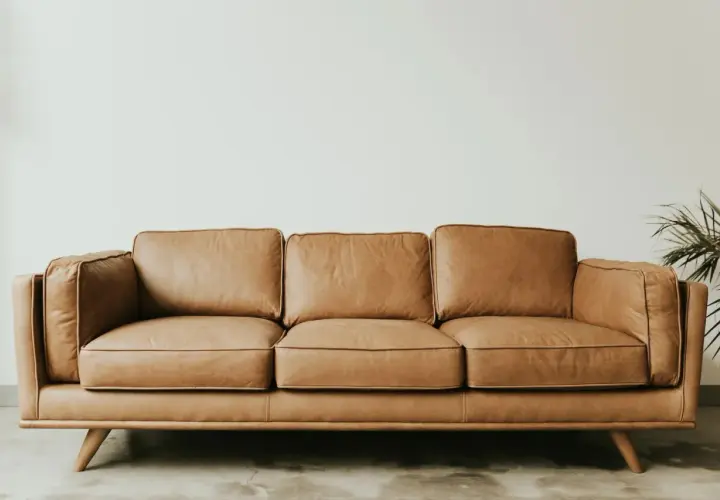 Canapé trois places en cuir aniline, couleur caramel, sur pieds en bois. Un fauteuil confortable pour votre salon.