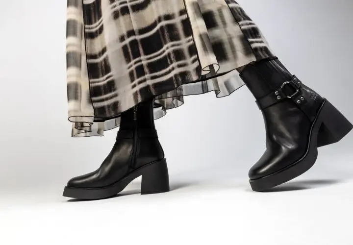 Jambes portant une robe à motif abstrait et une tenue avec bottines noires à talon épais et plateforme.