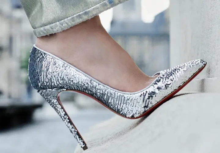 Une tenue jean avec talon, des escarpins argentés à paillettes brillent sous la lumière, prêts pour une soirée glamour.