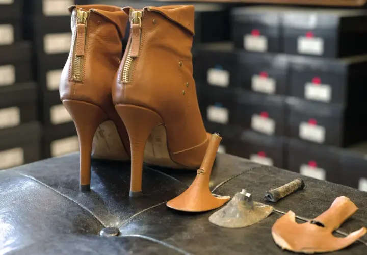 Paired brown leather ankle boots with zippers. One heel shows usure anormale talon chaussure, with the heel tip detached.
