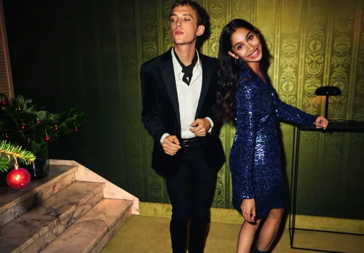 Un couple élégant, quelle tenue pour le réveillon du 31 ? Lui en smoking noir, elle dans une robe bleue à paillettes.