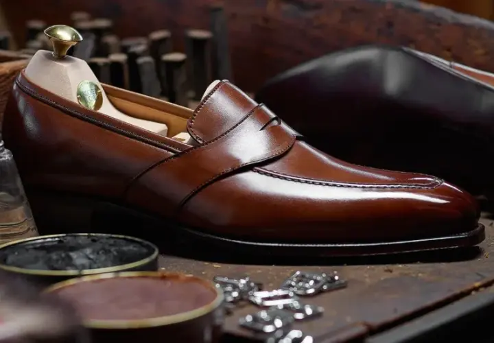 Un élégant mocassin en cuir marron, prêt à être lustré. Ce type de mocassin est un classique intemporel.