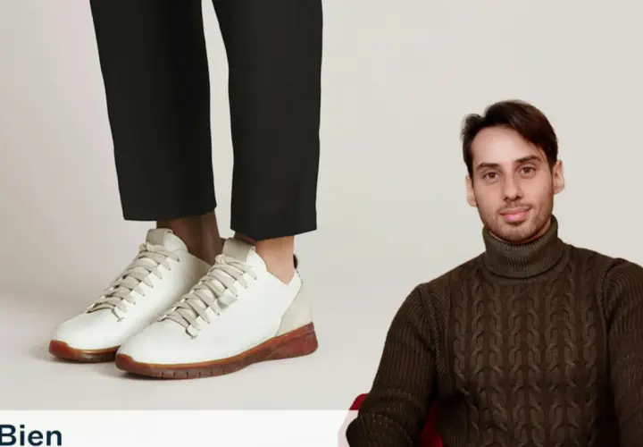 Un homme porte un pull à col roulé et un pantalon cigarette avec une chaussure blanche.