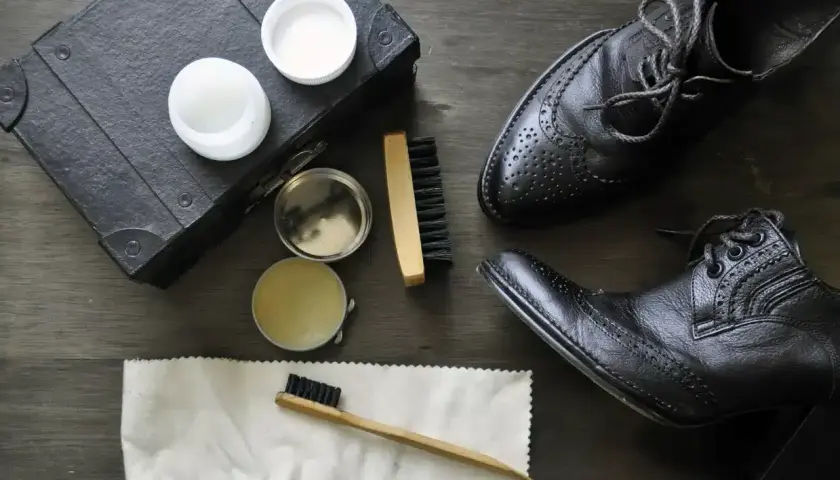 Comment cirer des chaussures sans cirage : des pots de baume, une brosse et un chiffon pour lustrer vos chaussures noires.