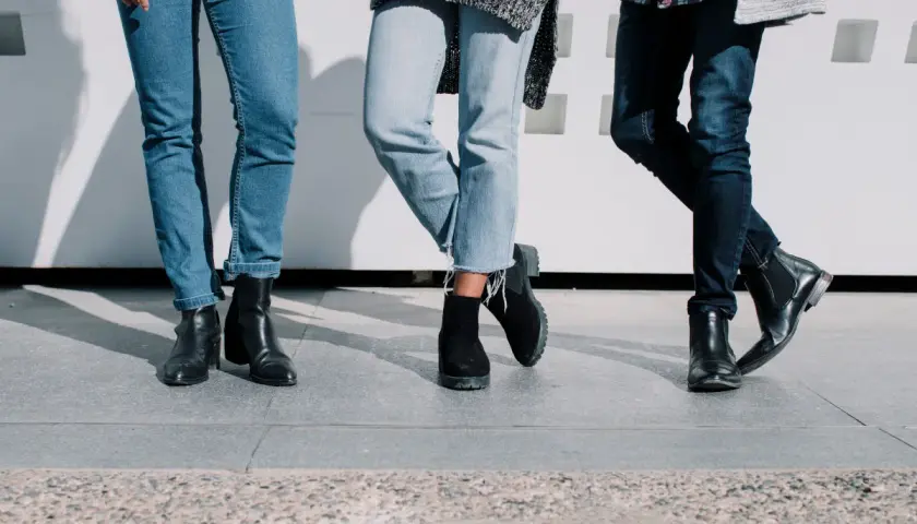 Trois paires de jambes portant des jeans et des bottes, un look décontracté et stylé.