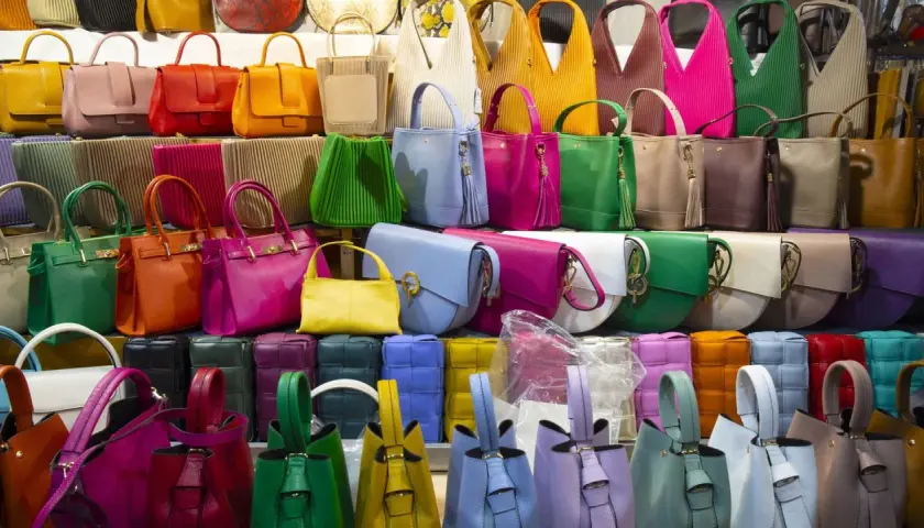 Un arc-en-ciel de sacs à main colorés, du vert émeraude au rose vif, offrant la couleur de sac à main qui va avec tout.