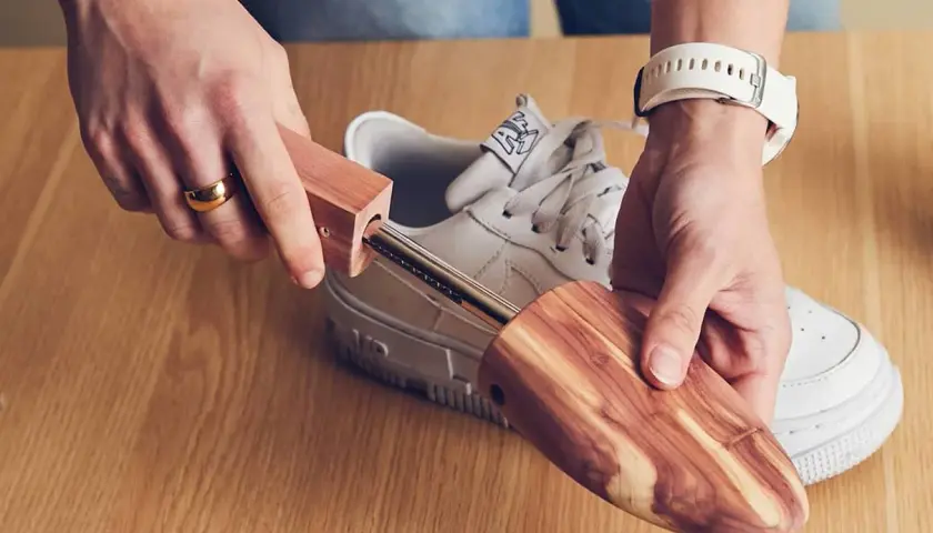 Utilisez un embauchoir en bois pour comment enlever les plis des chaussures. Il maintient la forme et absorbe l'humidité.