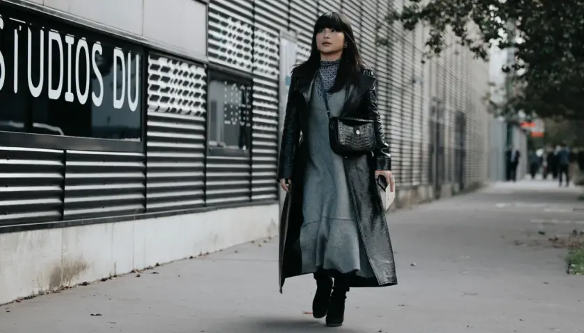 Une femme porte une robe grise et un long manteau noir verni, avec des bottines noires. Elle arbore un sac à main croco. Quelle chaussure mettre avec une robe noire et blanche ?