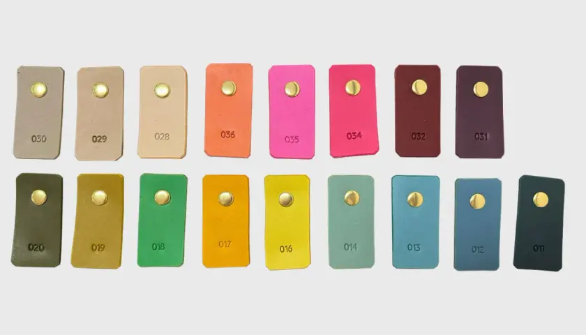 Échantillons de cuir aux teintes variées, du beige au prune, en passant par des couleurs vives comme le rose et l'orange. Chaque pièce présente une couleur de cuir distincte.