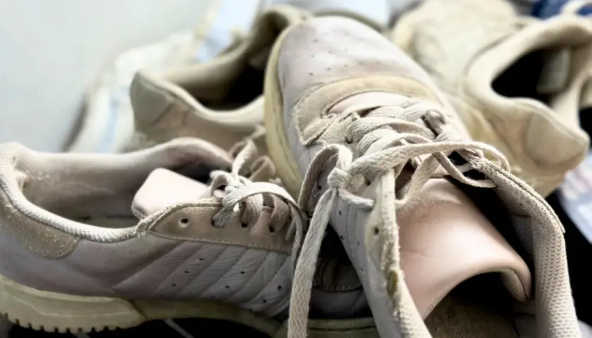Des baskets beiges un peu usées, prêtes pour un nettoyage. Apprenez comment nettoyer ses chaussures pour leur redonner vie.