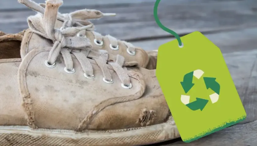Vieilles baskets usées avec un symbole de recyclage vert. Une question se pose : où jeter des chaussures ?