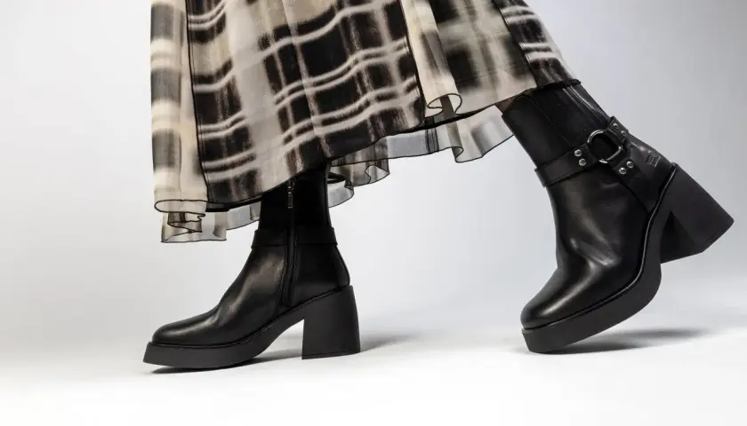 Jambes portant une robe à motif abstrait et une tenue avec bottines noires à talon épais et plateforme.