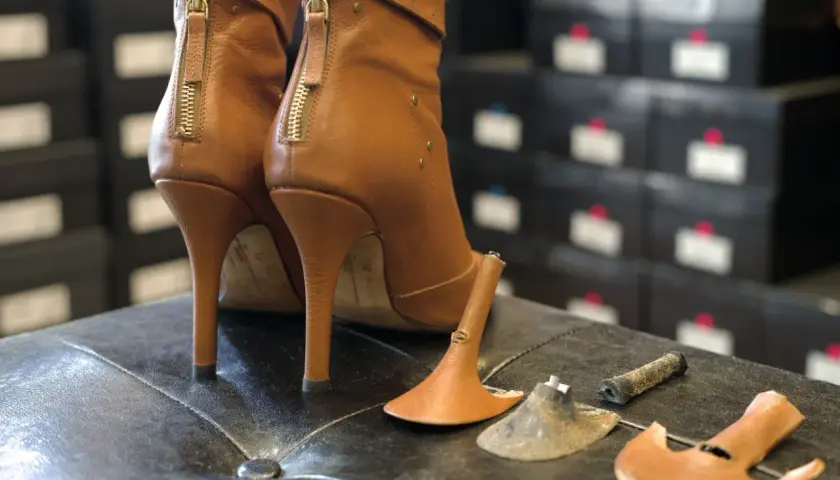 Paired brown leather ankle boots with zippers. One heel shows usure anormale talon chaussure, with the heel tip detached.