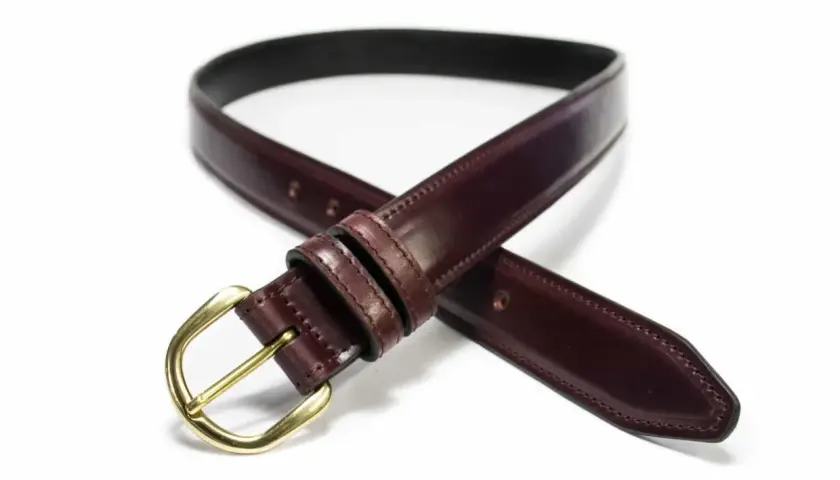 Ceinture élégante en cuir cordovan bordeaux avec boucle dorée, un accessoire intemporel pour parfaire votre tenue.