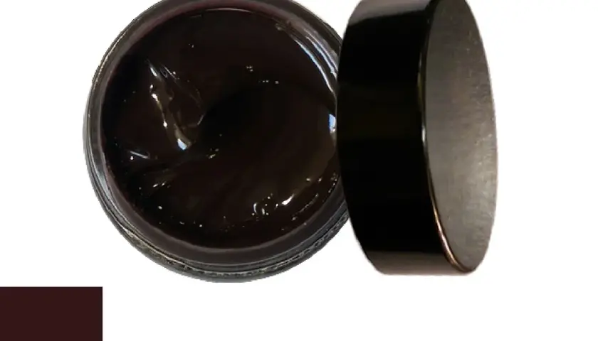 Pot de cirage marron foncé ouvert, avec son couvercle noir à côté. Idéal pour savoir comment enlever un cirage trop foncé.