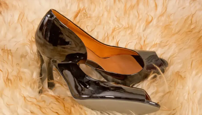 Paire de chaussures noires vernies sur fond pelucheux. Un guide pour l'entretien cuir vernis.